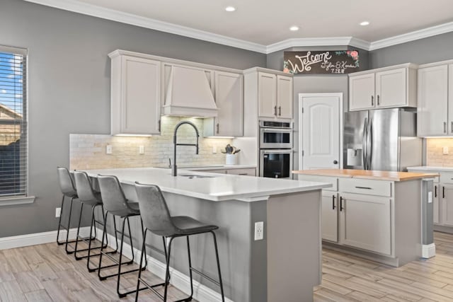 kitchen featuring stainless steel appliances, white cabinetry, a kitchen island, and sink