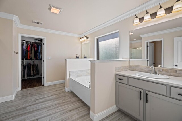 bathroom with vanity, wood-type flooring, ornamental molding, and separate shower and tub