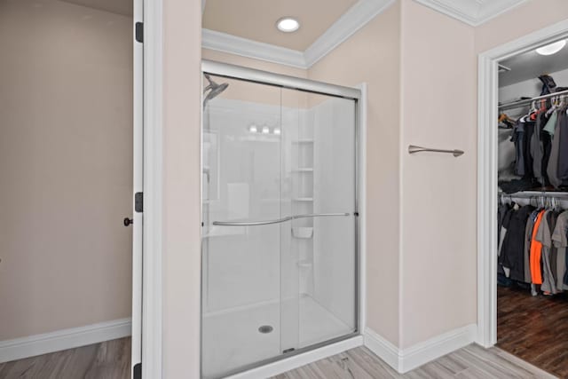 bathroom with walk in shower, ornamental molding, and wood-type flooring