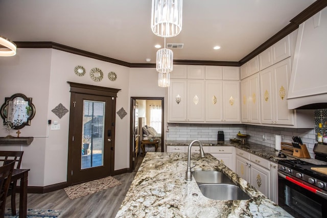 kitchen featuring white cabinetry, sink, stainless steel range with gas cooktop, and light stone countertops