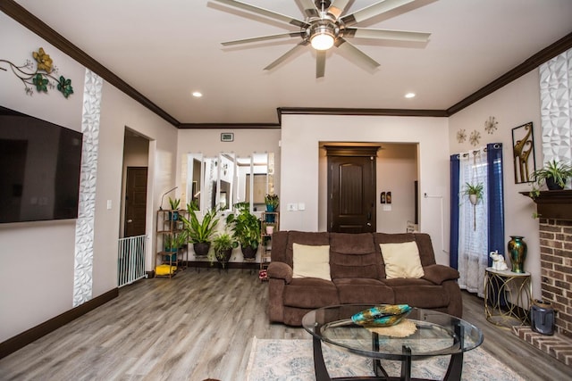 living room with hardwood / wood-style floors, ornamental molding, and ceiling fan