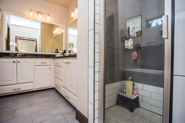 bathroom featuring vanity, tiled shower, and tile patterned floors