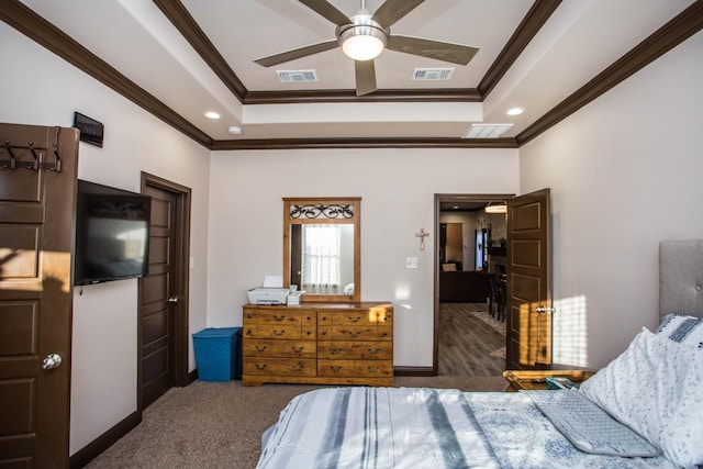 carpeted bedroom featuring a tray ceiling, ornamental molding, and ceiling fan