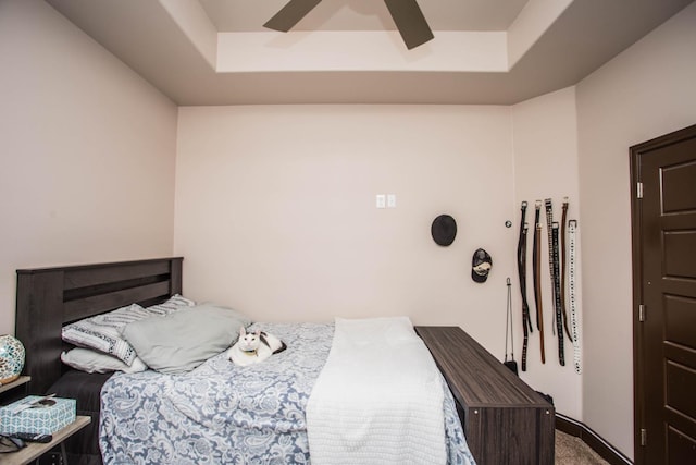 bedroom featuring ceiling fan, carpet flooring, and a raised ceiling