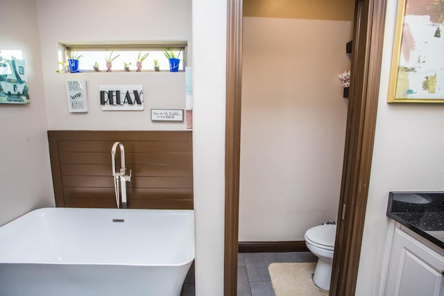 bathroom with vanity, tile patterned floors, a bathtub, and toilet