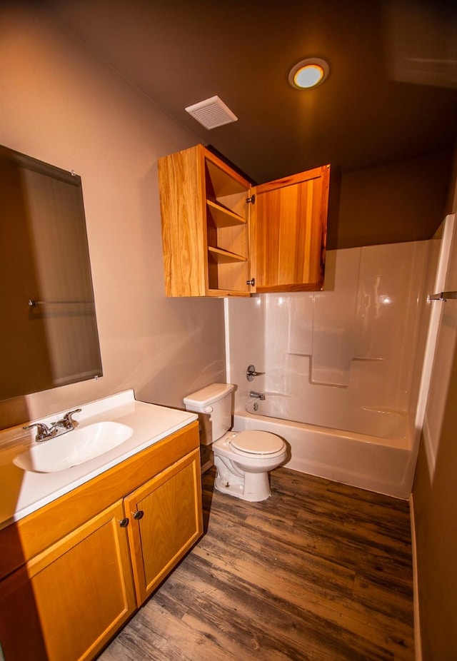 full bathroom with wood-type flooring, tub / shower combination, vanity, and toilet