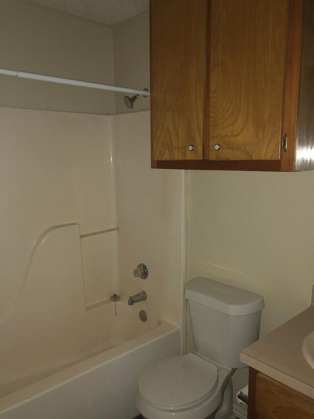 full bathroom featuring vanity, toilet, tub / shower combination, and a textured ceiling