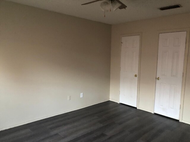 unfurnished bedroom with dark hardwood / wood-style floors and ceiling fan