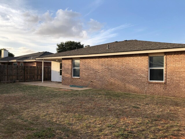 back of house featuring a patio and a yard