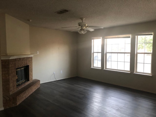 living room with a fireplace, dark wood-type flooring, plenty of natural light, and a textured ceiling