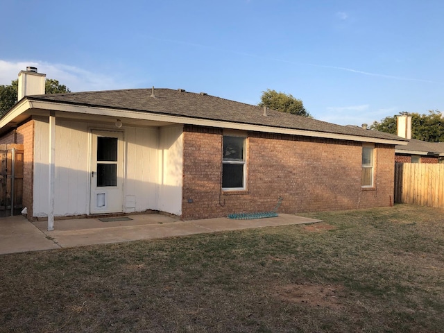 rear view of property featuring a patio area and a lawn