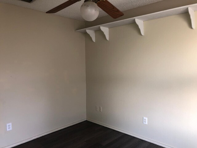 empty room featuring dark hardwood / wood-style flooring, a textured ceiling, and ceiling fan