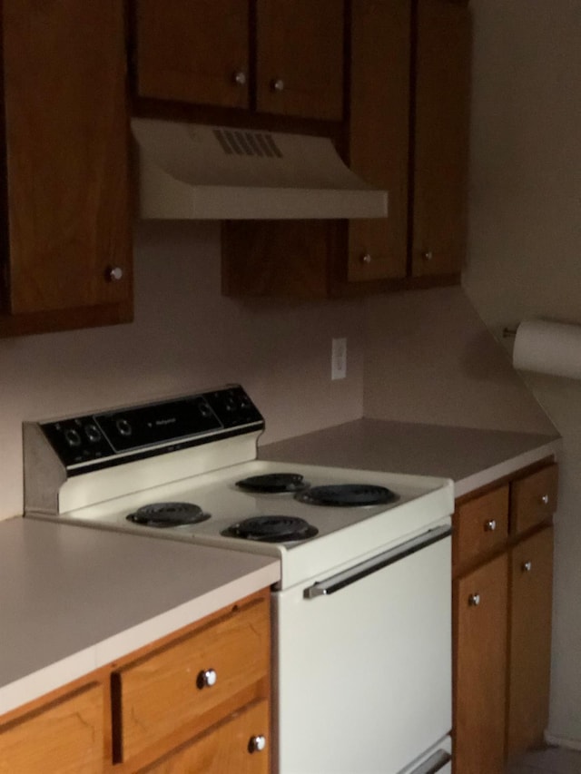 kitchen featuring ventilation hood and white range with electric stovetop