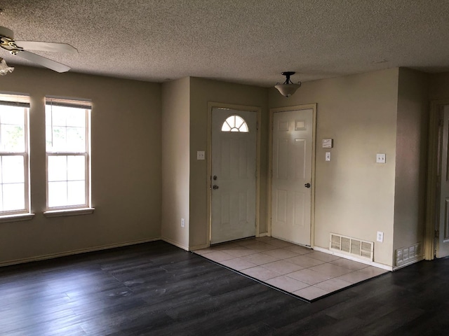 entrance foyer with ceiling fan, a textured ceiling, and light hardwood / wood-style floors