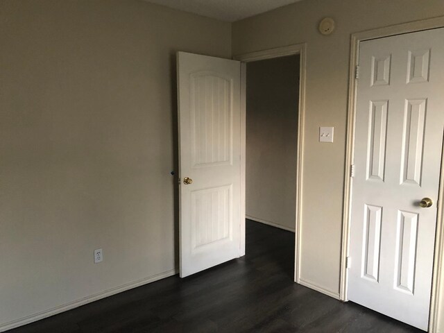 unfurnished bedroom featuring dark hardwood / wood-style flooring