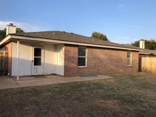 back of property featuring a yard and a patio area