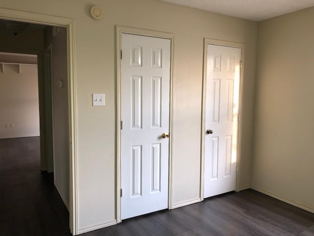 unfurnished bedroom featuring dark wood-type flooring