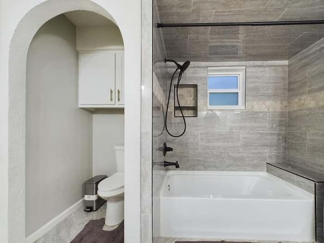 bathroom featuring tiled shower / bath and toilet