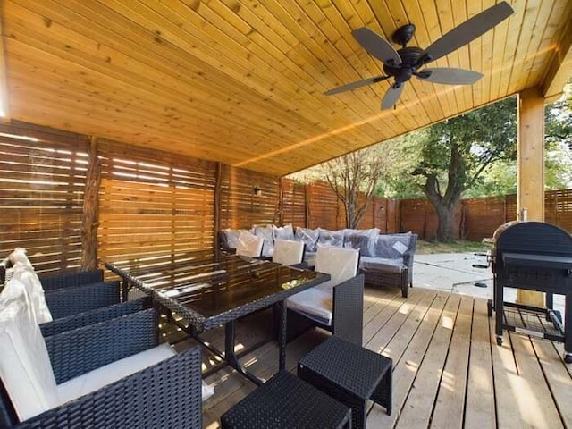 wooden deck with grilling area, an outdoor hangout area, and ceiling fan