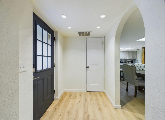 foyer entrance with sink and light hardwood / wood-style floors