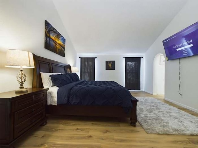 bedroom with vaulted ceiling and light hardwood / wood-style floors