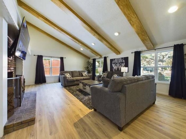 living room featuring a brick fireplace, high vaulted ceiling, beam ceiling, and light hardwood / wood-style floors