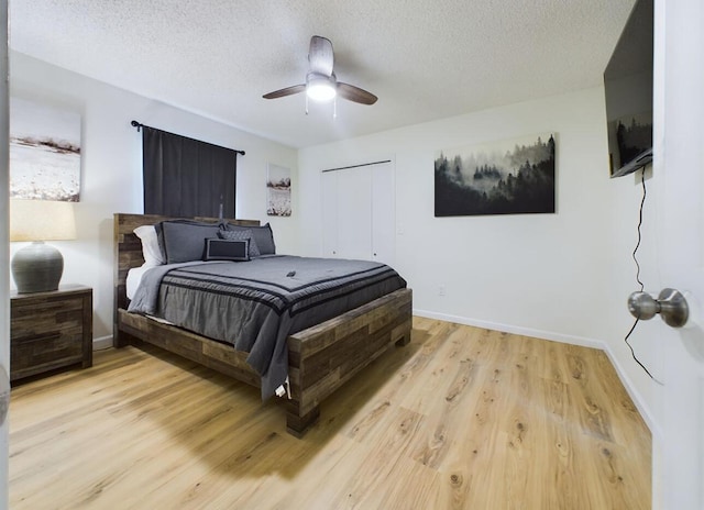 bedroom with ceiling fan, light hardwood / wood-style floors, and a textured ceiling