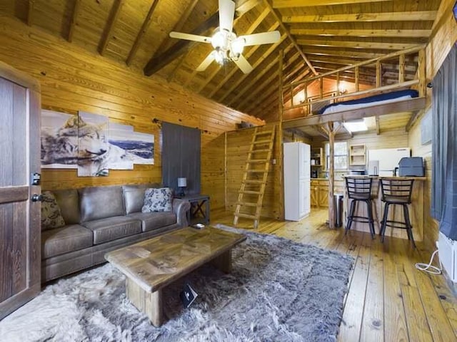 living room featuring high vaulted ceiling, wooden walls, beamed ceiling, ceiling fan, and hardwood / wood-style floors