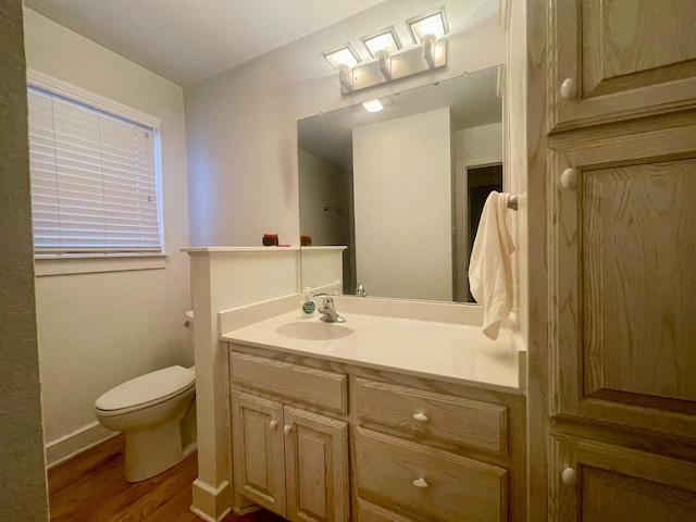 bathroom with vanity, wood-type flooring, and toilet