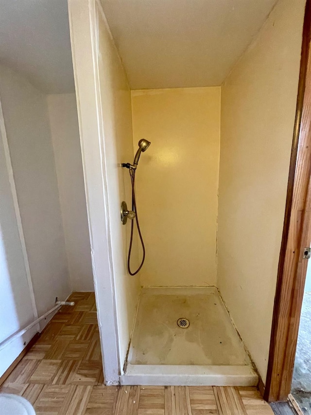 bathroom featuring parquet flooring and a shower