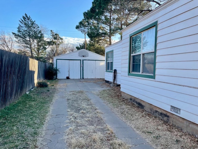 view of side of home with a garage and an outbuilding