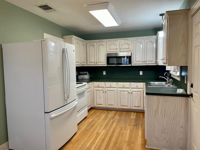 kitchen featuring sink, light brown cabinets, white appliances, and light hardwood / wood-style flooring