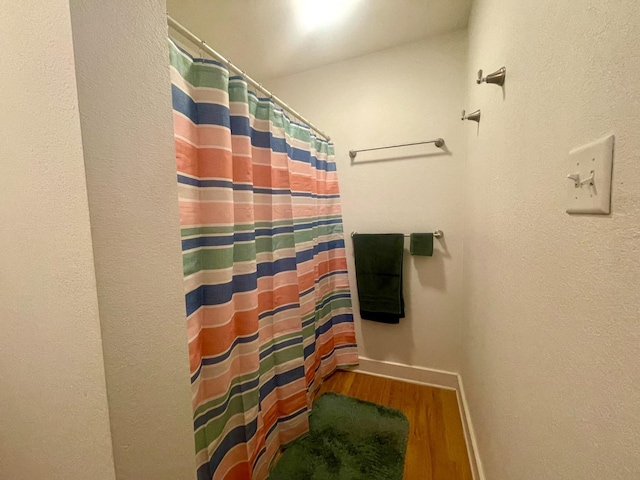 bathroom featuring hardwood / wood-style floors and a shower with curtain