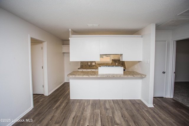 4638 Fordham St, Lubbock, TX 79416 - kitchen with a peninsula, decorative backsplash, dark wood-type flooring, light countertops, and white cabinetry