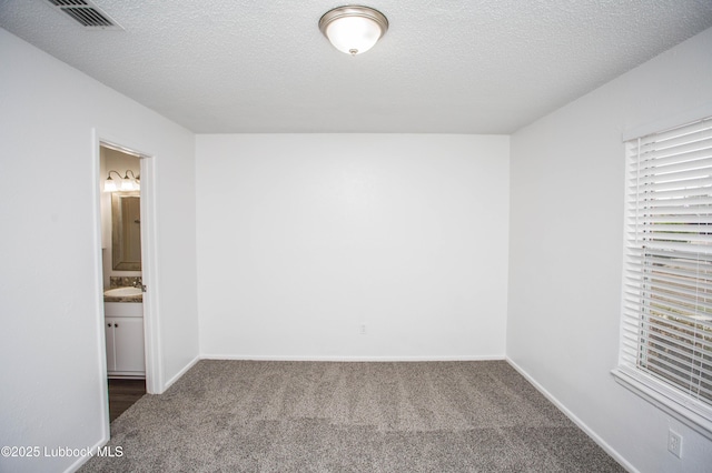 4638 Fordham St, Lubbock, TX 79416 - unfurnished bedroom featuring carpet flooring, a textured ceiling, and connected bathroom