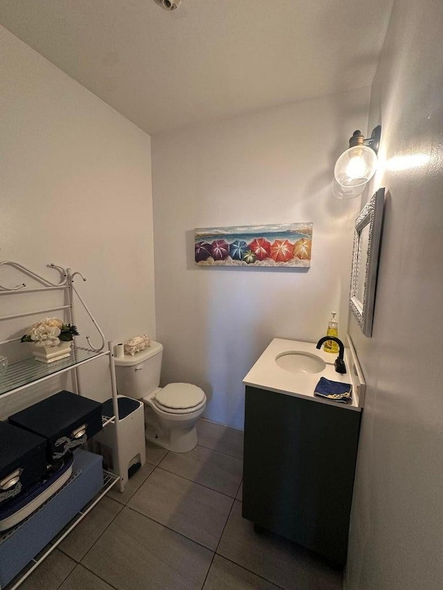 bathroom with tile patterned flooring, vanity, and toilet