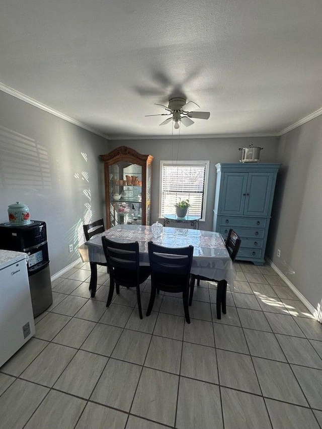 tiled dining area with ceiling fan, ornamental molding, and a textured ceiling