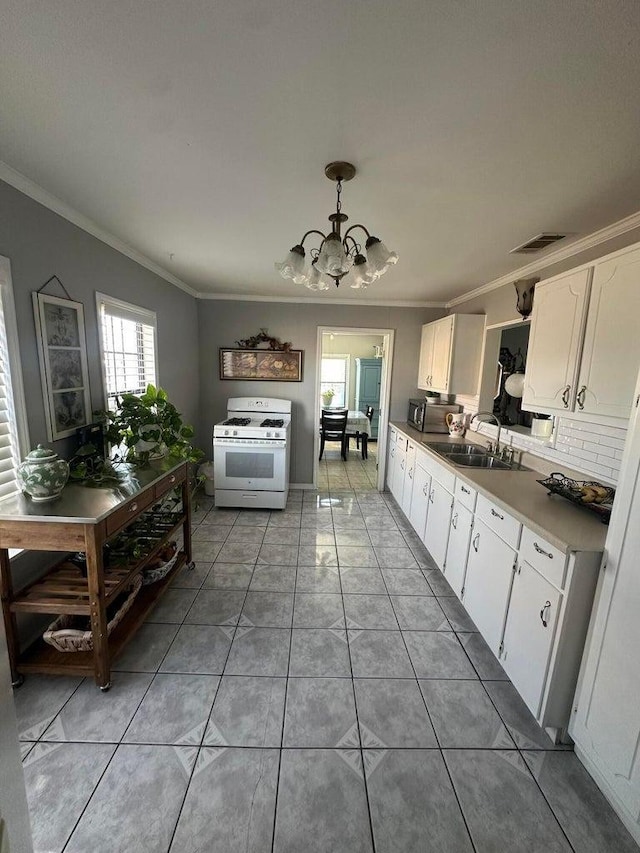 kitchen with decorative light fixtures, white gas range, sink, white cabinets, and crown molding