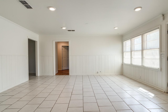 empty room featuring ornamental molding and light tile patterned floors