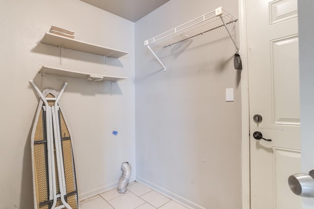 washroom with electric dryer hookup and light tile patterned floors