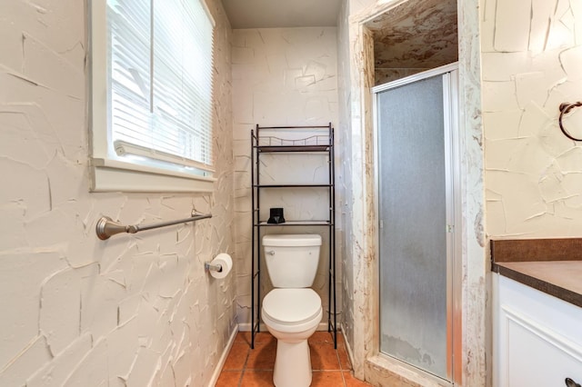 bathroom featuring tile patterned flooring, vanity, a shower with door, and toilet