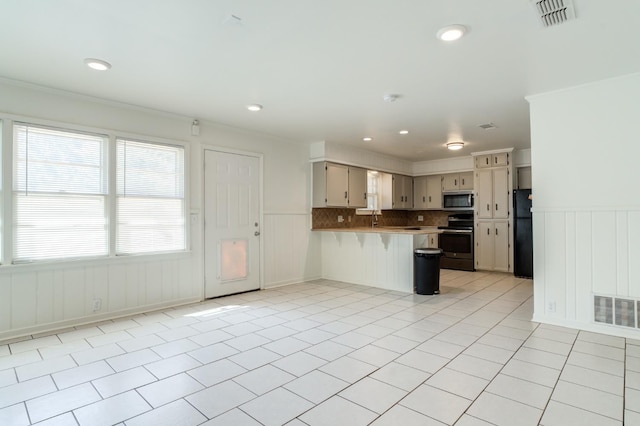 kitchen with sink, light tile patterned floors, crown molding, appliances with stainless steel finishes, and kitchen peninsula