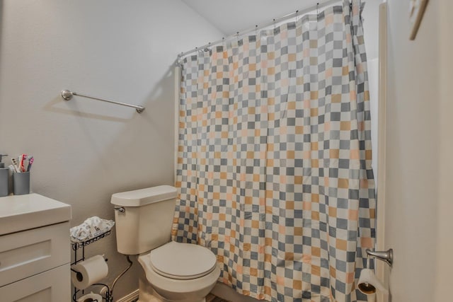 bathroom with walk in shower, vanity, and toilet