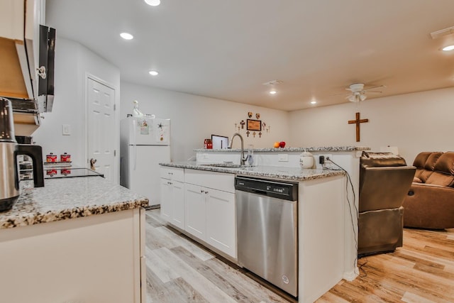 kitchen featuring dishwasher, an island with sink, sink, white cabinets, and white fridge