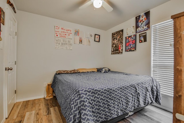 bedroom with multiple windows, wood-type flooring, and ceiling fan