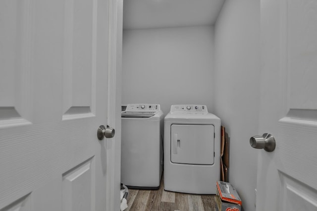 laundry room featuring washer and dryer and light hardwood / wood-style floors