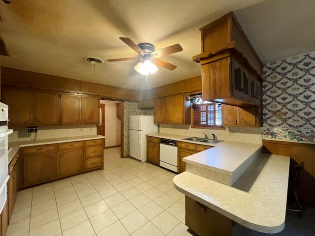 kitchen featuring light tile patterned floors, sink, white appliances, ceiling fan, and kitchen peninsula