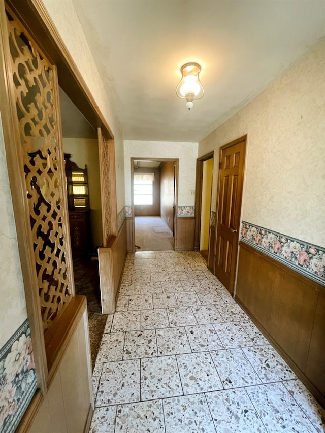 hallway featuring wooden walls