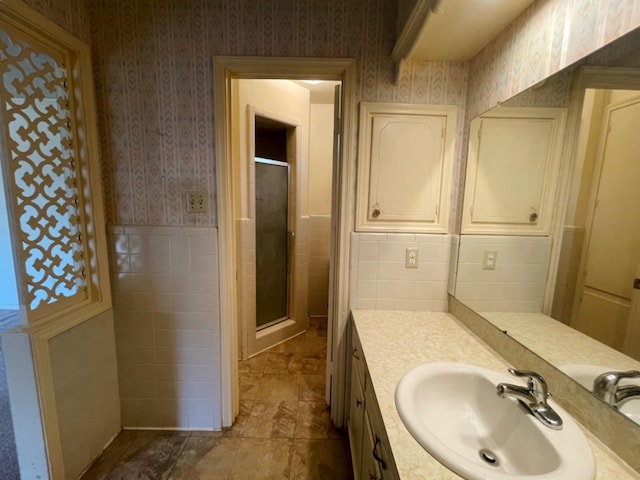 bathroom featuring vanity, tile walls, and a shower with shower door