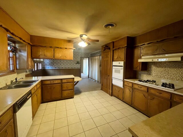 kitchen with tasteful backsplash, sink, light tile patterned floors, ceiling fan, and white appliances